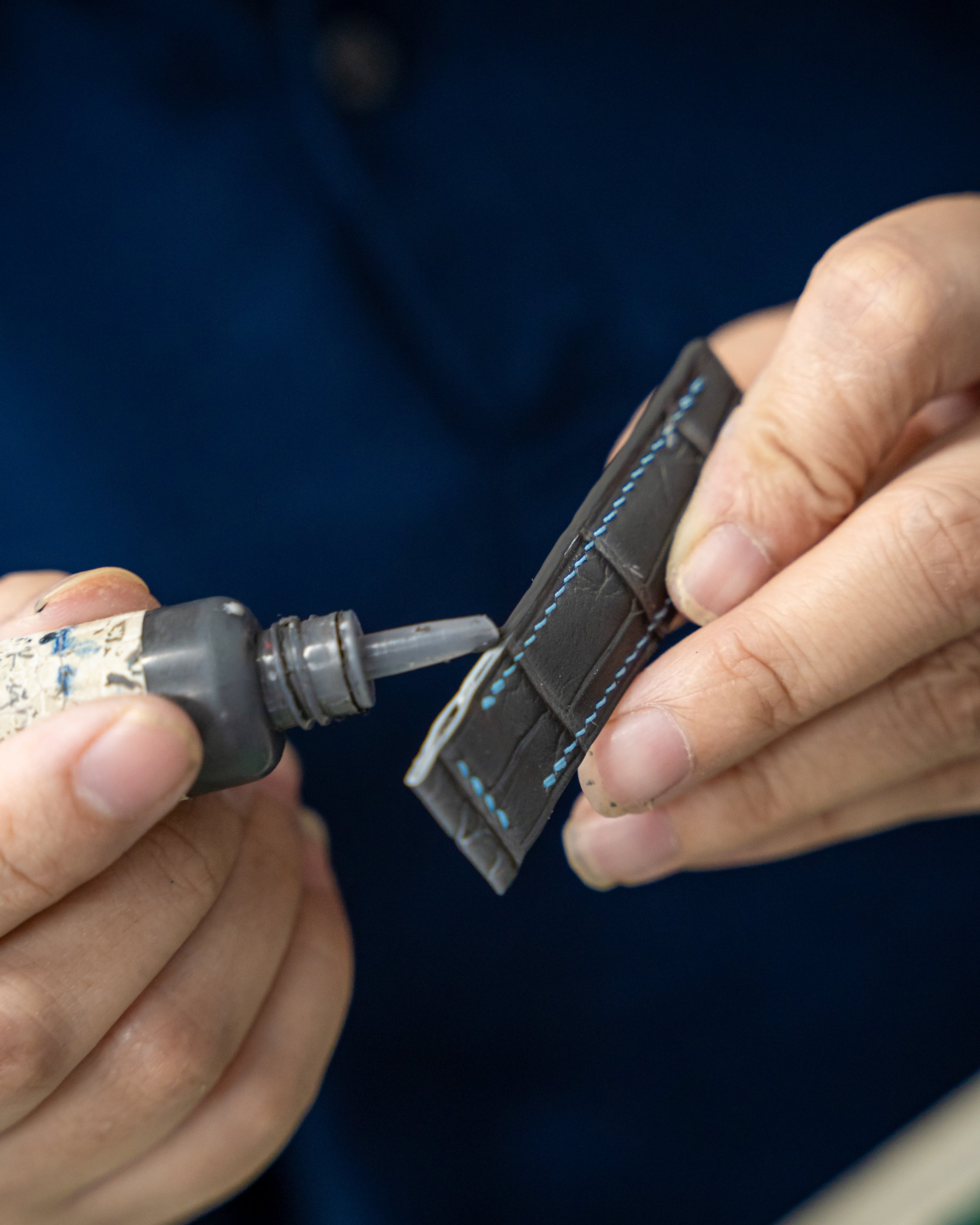 Hand-finishing a strap edge in the Delugs atelier